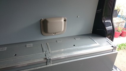 Vue d'ensemble du coffre de rangement avec sont système de lit coté droit.